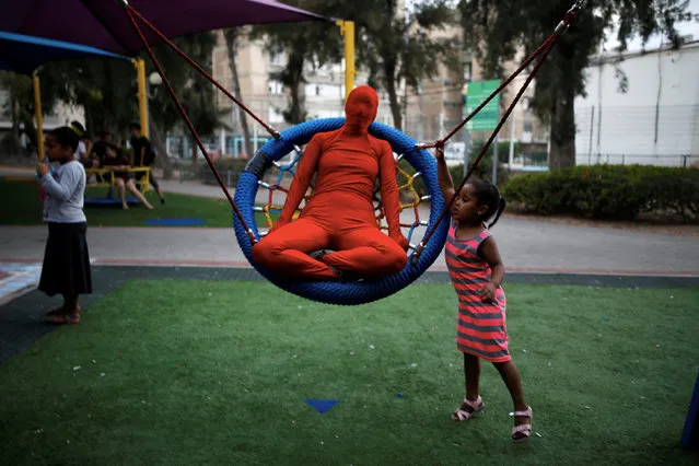 A group member of street artists, collectively known as “Prizma Ensemble”, wear full solid-coloured bodysuits as they perform at a Playground in Ashdod, Israel July 13, 2017. (Photo by Amir Cohen/Reuters)