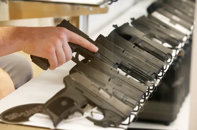 A handgun is pulled form the case at the “Ready Gunner” gun store in Provo, Utah, U.S., June 21, 2016. (Photo by George Frey/Reuters)