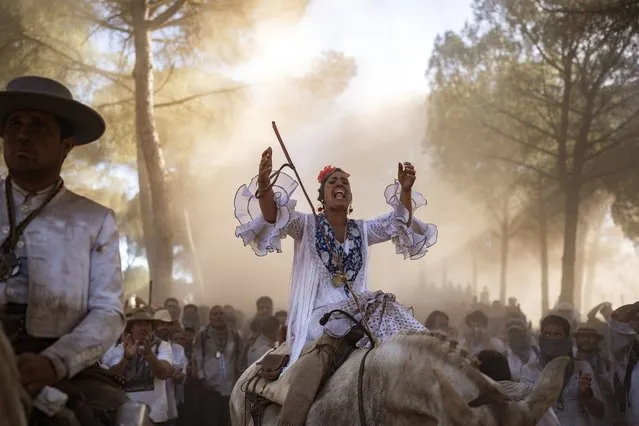 DesirÈe M·rquez Carrasco, from Hermandad de Huelva, rides her horse in the Donana National Park on their way to the shrine of El Rocio in Almonte, Spain, on Friday, June 3, 2022, during the annual pilgrimage in which hundreds of thousands of devotees of the Virgin del Rocio converge in and around the shrine. (Photo by Joan Mateu Parra/AP Photo)