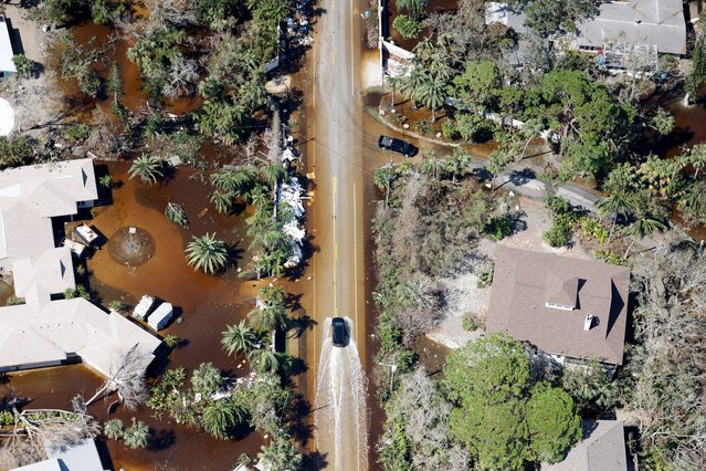 An aerial view shows cars driving through flooded streets after Hurricane Milton's landfall, in Siesta Key, Florida, on October 10, 2024. (Photo by Marco Bello/Reuters)