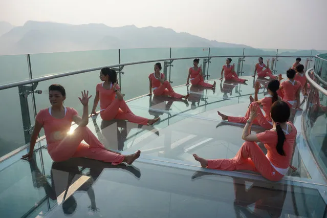 People practise yoga on a glass sightseeing platform ahead of the International Day of Yoga, on the outskirts of Beijing, China, June 20, 2016. (Photo by Reuters/Stringer)