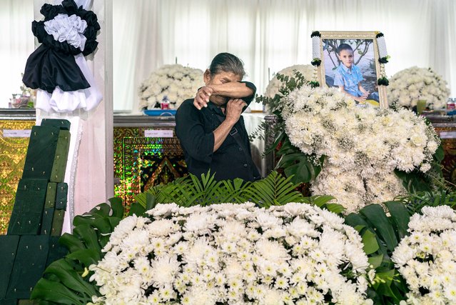 A relative cries in front of the portrait and coffin of a victim of a school bus fire at Wat Khao Phraya Sangkharam School in Uthai Thani, on October 3, 2024. Grieving families wept as they offered prayers for 23 children and their teachers killed in a horrifying Thai school bus fire, as the government vowed a crackdown on unsafe vehicles. (Photo by Chanakarn Laosarakham/AFP Photo)