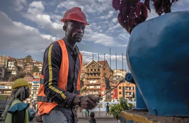 Workers apply a coat of fresh paint to the Place de l'Indépendance on the eve of the arrival of King Philippe and Queen Mathilde of Belgium in Bukavu, Democratic Republic of Congo, on June 11, 2022. At the request of the mayor of the city of Bukavu to welcome the King and Queen of Belgium to Bukavu, the population must paint their houses on the main road. (Photo by Guerchom Ndebo/AFP Photo)