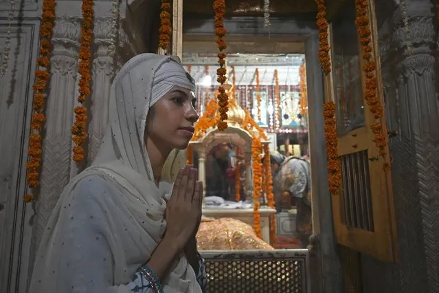 A Sikh pilgrim offers prayers at a gurdwara in Lahore on June 16, 2022, as Sikh pilgrims from India and other parts of the world arrived in Pakistan to take part in religious rituals for the fifth Sikh Guru Arjan Dev Ji's 416th death anniversary. (Photo by Arif Ali/AFP Photo)