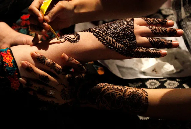 Women get Henna tattoos (Mehndi) ahead of Eid al-Fitr, which marks the end of the Muslim holy fasting month of Ramadan, at a market in Islamabad, Pakistan July 6, 2016. (Photo by Caren Firouz/Reuters)