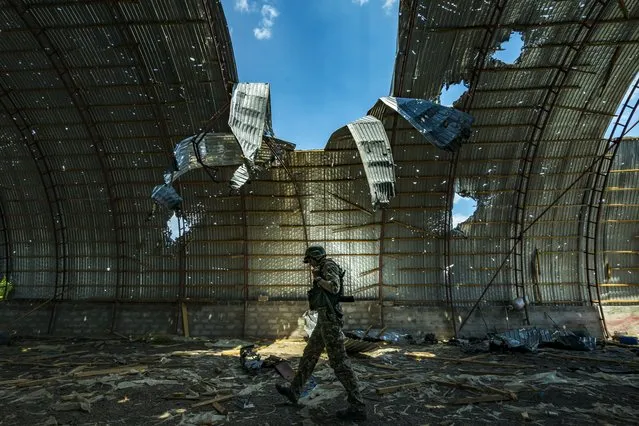 A ukrainian soldier walks inside a destroyed barn by russian shelling near the frontline of the Zaporizhzhia province, Ukraine on June 12, 2022. Harvest can not be collected in the area because the constant combats between russian and ukrainian armies in the fields. (Photo by Celestino Arce Lavin/ZUMA Press Wire/Rex Features/Shutterstock)