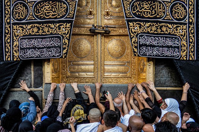 Muslim worshippers reach to touch the golden doors Kaaba, Islam's holiest shrine, while performing the “Umrah” pilgrimage circumambulation or “tawaf”, circling seven times around it at the Grand Mosque in the holy city of Mecca on September 6, 2023. The Kaaba is a stone building at the centre of Islam's most important mosque and holiest site, the “Masjid al-Haram” (Holiest Mosque) in Mecca, Saudi Arabia. It is the “qibla” (direction of prayer) for Muslims around the world. (Photo by Sameer Al-Doumy/AFP Photo)