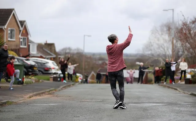 Janet Woodcock leads a dance class for residents in a street in Frodsham, as the spread of the coronavirus disease (COVID-19) continues, Frodsham, Britain, April 1, 2020. (Photo by Molly Darlington/Reuters)