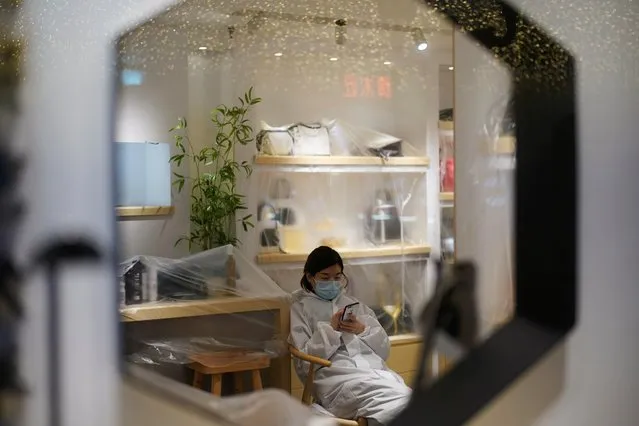 A staff member checks her mobile phone inside a closed store at a shopping complex in Wuhan, Hubei province, the epicentre of China's coronavirus disease (COVID-19) outbreak, March 31, 2020. (Photo by Aly Song/Reuters)