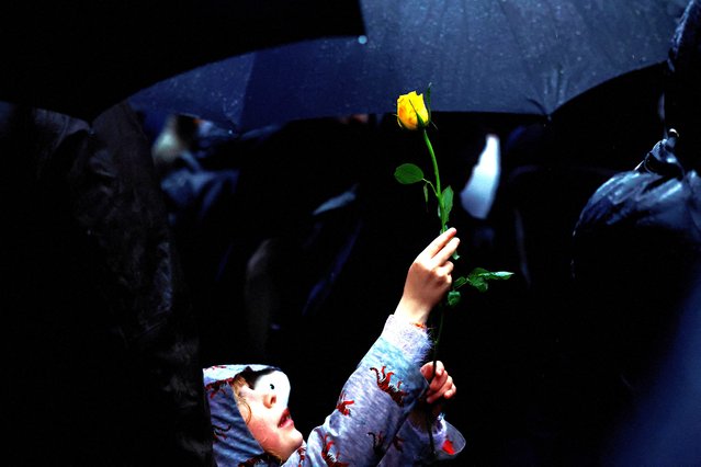 Octavia Jeram, 6, holds up a yellow rose as demonstrators hold a vigil outside Downing Street in solidarity with Palestinians after the Al-Ahli hospital blast in Gaza, amid the ongoing conflict between Israel and the Palestinian Islamist group Hamas, in London, Britain on October 18, 2023. (Photo by Clodagh Kilcoyne/Reuters)
