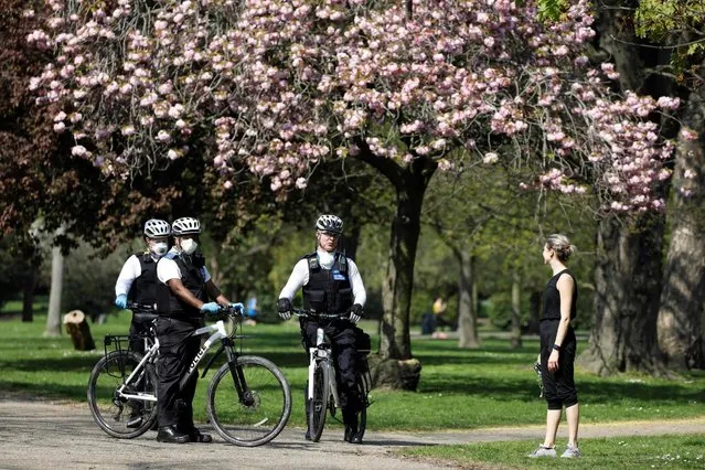 Officers of the Metropolitan Police patrol in Victoria Park, east London on April 11, 2020 as warm weather tests the nationwide lockdown due to the novel coronavirus COVID-19 and the long Easter weekend begins. The disease has struck at the heart of the British government, infected more than 60,000 people nationwide and killed over 8,000, with a daily death toll in England of 866 reported on April 10. (Photo by Tolga Akmen/AFP Photo)