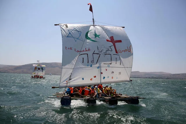 Israeli youths, of Arab and Jewish descent, sail on a handmade raft across the Sea of Galilee in northern Israel on August 4, 2016, as part of a three day summer camp program organized by the Israeli Kibbutz movement, for Arabs and Jews, aimed to bridge the gap between the different societies in Israel. (Photo by Menahem Kahana/AFP Photo)