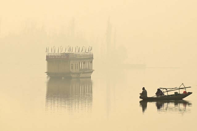 A man rows his boat in the waters of Dal Lake amid foggy conditions in Srinagar on December 6, 2024. (Photo by Tauseef Mustafa/AFP Photo)