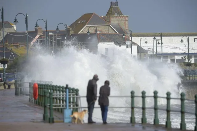 A couple watch waves break on the sea wall at Penzanze, southwestern England as the remnants of  Hurricane Ophelia begins to hit parts of Britain and Ireland. Ireland's meteorological service is predicting wind gusts of 120 kph to 150 kph (75 mph to 93 mph), sparking fears of travel chaos. Some flights have been cancelled, and aviation officials are warning travelers to check the latest information before going to the airport Monday. (Photo by Ben Birchall/PA Wire via AP Photo)