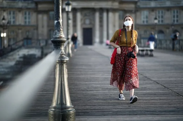 A woman wearing a protective mask walks at the Pont des Arts bridge during the outbreak of the coronavirus disease (COVID-19) in Paris, France, May 2, 2020. (Photo by Benoit Tessier/Reuters)