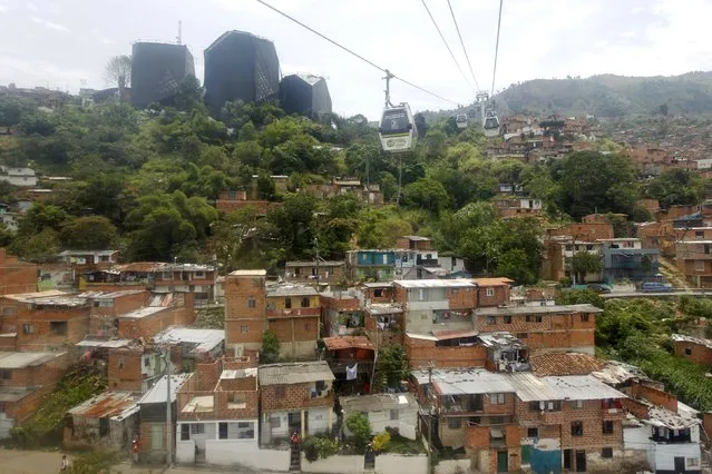 Cable cars of the Metrocable transport system are pictured over the “Comuna 13” neighborhood in Medellin, Colombia September 8, 2015. (Photo by Fredy Builes/Reuters)