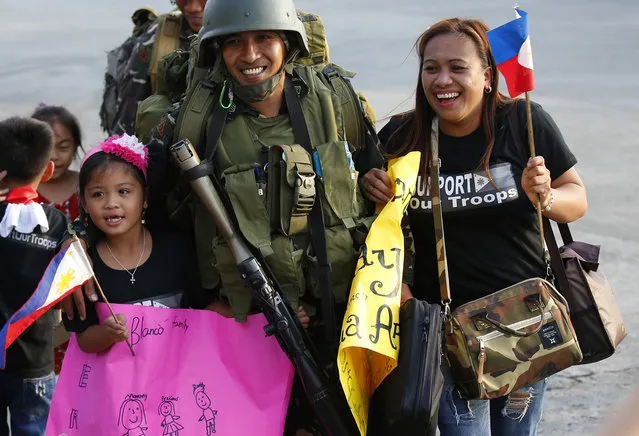 Relatives welcome home troops in one of the first battalions to be deployed in the besieged city of Marawi in southern Philippines, at Villamor Air Base Friday, October 20, 2017 in Pasay city, southeast of Manila, Philippines. The Philippine military has begun to scale down their forces three after President Rodrigo Duterte declared the liberation of Marawi city following the killings of the militant leaders after five months of military offensive. (Photo by Bullit Marquez/AP Photo)