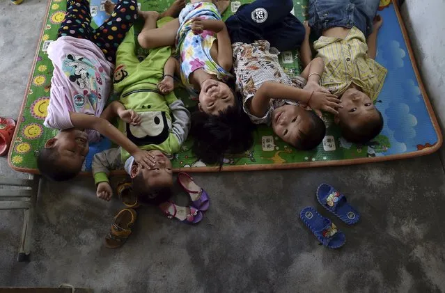 Students play as they sleep on a mat on the ground at Dalu primary school in Gucheng township of Hefei, Anhui province, China, September 8, 2015. (Photo by Reuters/Stringer)