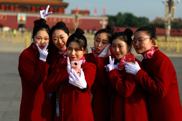 Chinese hostesses take selfies on Tiananmen Square before the closing ceremony of the 19th National Congress of the Communist Party of China (CPC) at the Great Hall of the People (GHOP) in Beijing, China, 24 October 2017. According to media reports on 24 October 2017, the National Congress of the Communist Party of China voted to enshrine the signature ideology of President Xi Jinping into the Chinese Communist Party constitution, elevating him to the country's most influential and powerful leader in decades. President Xi Jinping was also granted another five years in power during 19th Congress of the Communist Party of China. (Photo by How Hwee Young/EPA/EFE)