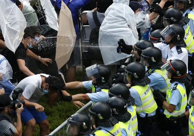 Riot police use pepper spray as they clash with protesters, as tens of thousands of protesters block the main street to the financial Central district outside the government headquarters in Hong Kong September 28, 2014. (Photo by Bobby Yip/Reuters)