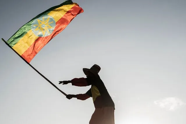 A man waves an Ethiopian flag as he join others gathering in Addis Ababa, Ethiopia, on October 22, 2022 during a demonstration in support of Ethiopia armed forces. Tigray's rebel authorities said Friday they would attend talks next week aimed at ending war in Ethiopia, as Prime Minister Abiy Ahmed vowed fighting “will end and peace will prevail” The government has also said it would participate in negotiations in South Africa on Monday being organised by the African Union, as diplomatic pressure mounts for a settlement to almost two years of bloodshed. (Photo by Amanuel Sileshi/AFP Photo)
