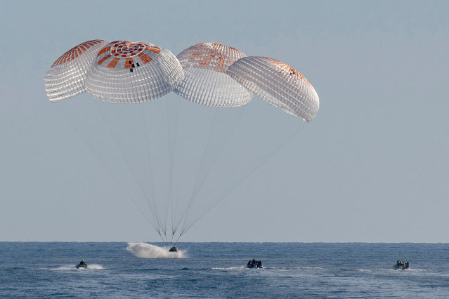 This handout picture provided by NASA shows support teams work around a SpaceX Dragon spacecraft shortly after it landed with NASA astronauts Nick Hague, Suni Williams, Butch Wilmore, and Roscosmos cosmonaut Aleksandr Gorbunov aboard in the water off the coast of Tallahassee, Florida, on March 18, 2025. (Photo by Keegan Barber/NASA via AFP Photo)