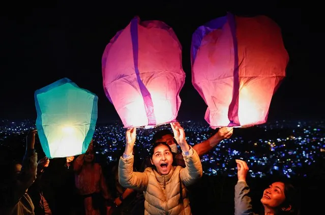 People prepare to release lanterns from a hilltop during the Tihar festival, the Hindu festival of lights in Kathmandu, Nepal on October 23, 2022. (Photo by Navesh Chitrakar/Reuters)