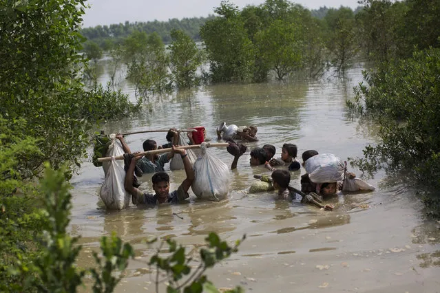 A Rohingya family reaches the Bangladesh border after crossing a creek of the Naf river on the border with Myanmar, in Cox's Bazar's Teknaf area, on September 5, 2017. (Photo by Bernat Armangue/AP Photo)