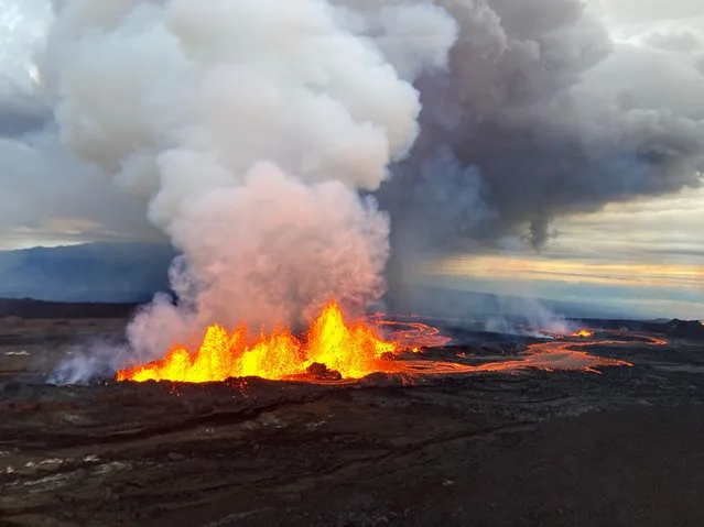 This image released by the US Geological Survey (USGS) on November 29, 2022, shows an aerial photograph of the dominant fissure 3 erupting on the Northeast Rift Zone of Mauna Loa in Hawaii. Fountains of lava up to 200 feet (60 meters) high have been fired into the air from Mauna Loa, geologists say, generating rivers of molten rock from the world's largest active volcano. Four fissures have now opened up on the mammoth mountain, which burst into life on November 27, 2022 for the first time in almost 40 years. (Photo by Handout/US Geological Survey/AFP Photo)