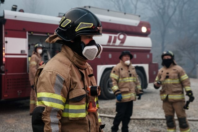 Firefighters work after most of the buildings were burned to the ground in a wildfire at Gounsa Temple in Uiseong on March 26, 2025. At least 18 people have been killed in one of South Korea's worst wildfire outbreaks, with multiple blazes burning and causing “unprecedented damage”, the acting president said. (Photo by Yasuyoshi Chiba/AFP Photo)