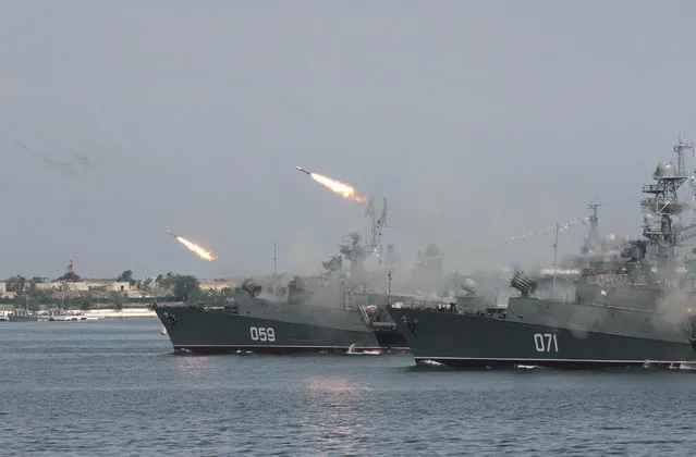 Russian warships fire during a naval parade rehearsal in the Crimean port of Sevastopol, July 25, 2014. (Photo by Reuters/Stringer)
