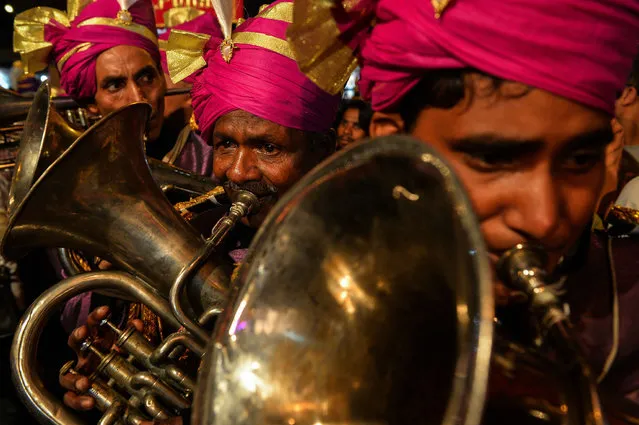 Members of an Indian wedding band play brass instruments during a religious procession for the Hindu festival Ganesh Chaturthi in New Delhi on September 24, 2015. (Photo by Chandan Khanna/AFP Photo)