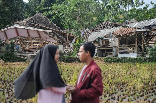 Locals stands near damaged houses after earthquake hit in Cianjur, West Java province, Indonesia on November 22, 2022. (Photo by Raisan Al Farisi/Antara Foto)