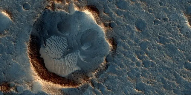 A location on Mars associated with the best-selling novel and Hollywood movie, "The Martian is seen in an image from the High Resolution Imaging Science Experiment (HiRISE) camera on NASA's Mars Reconnaissance Orbiter taken May 17, 2015. This area is in the Acidalia Planitia region and in the novel and the movie, it is the landing site of a crewed mission named Ares 3. (Photo by Reuters/NASA/JPL-Caltech/Univ. of Arizona)
