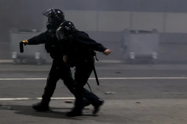 A policeman helps an injured colleague during clashes with protesters in Kosovo's capital Pristina October 12, 2015. Protesters besieged the central police station in Kosovo on Monday, hours after the arrest of a prominent opposition politician, lobbing concrete and stones at police who returned fire with teargas. (Photo by Hazir Reka/Reuters)