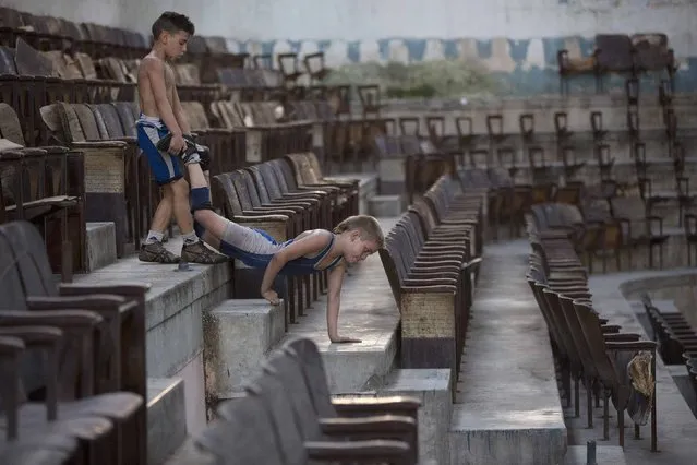 Jonatan Leliebre, 10 (L), and Oscar Torres, 9, exercise before a wrestling practice session at an old Basque ball gymnasium in downtown Havana, October 30, 2014. (Photo by Alexandre Meneghini/Reuters)