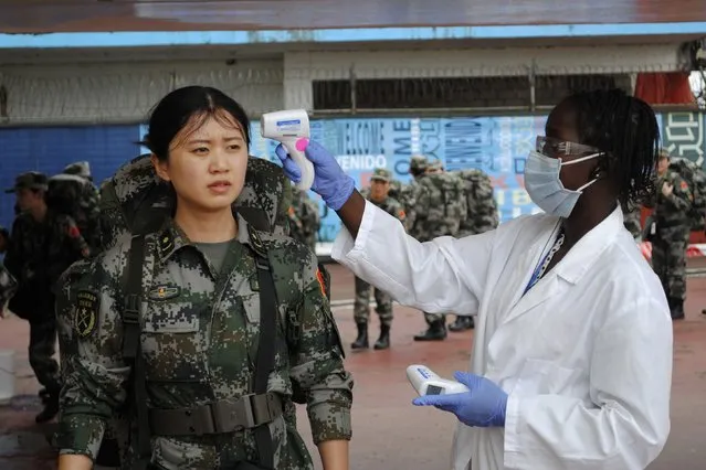 A Chinese military health worker, part of a delegation sent by China to help in the fight against Ebola, has her temperature taken as she arrives at Roberts airport outside Monrovia November 15, 2014. China is dispatching health experts and medical staff to Liberia and Sierra Leone in response to U.N. calls for a greater global effort to fight the deadly Ebola virus in West Africa. (Photo by James Giahyue/Reuters)