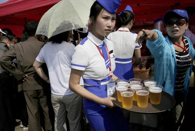 A waitress serves beers during an air festival on Saturday, September 24, 2016, in Wonsan, North Korea. (Photo by Wong Maye-E/AP Photo)