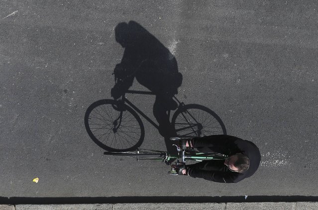 A man casts his shadow as he rides along a cycle superhighway in London, Britain May 15, 2016. (Photo by Neil Hall/Reuters)