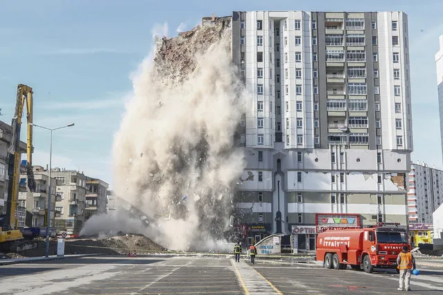 Construction vehicles demolish a damaged 12-storey-building in Kayseri after 7.7 and 7.6 magnitude earthquakes hit multiple provinces of Turkiye on February 21, 2023. (Photo by Sercan Kucuksahin/Anadolu Agency via Getty Images)