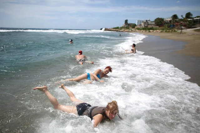 Tourists from Canada and Russia enjoy the beach before the arrival of Hurricane Matthew in Siboney, Cuba, October 2, 2016. (Photo by Alexandre Meneghini/Reuters)