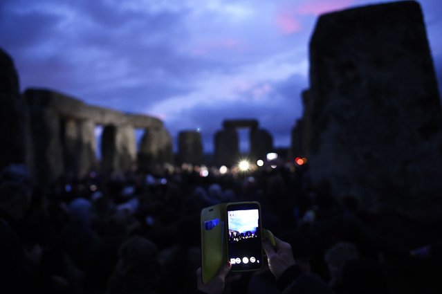 A reveller records people as they celebrate the sun rise during the winter solstice at Stonehenge on Salisbury plain in southern England December 22, 2014. (Photo by Dylan Martinez/Reuters)