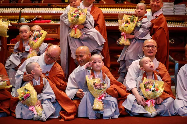 Novice monks who had their heads shaved by pose for photographs with Buddhist monks during an event to celebrate the upcoming Vesak Day, the birthday of Buddha, at Jogye temple in Seoul, South Korea, May 2, 2018. (Photo by Kim Hong-Ji/Reuters)