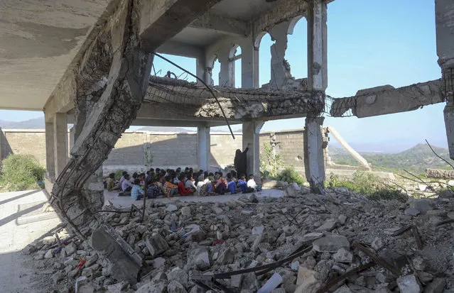 Yemeni pupils attend class on the first day of the new academic year, in a makeshift classroom in their school compound which was heavily damaged two years ago in an air strike, in the country's third-city of Taez on October 7, 2020. (Photo by Ahmad Al-Basha/AFP Photo)