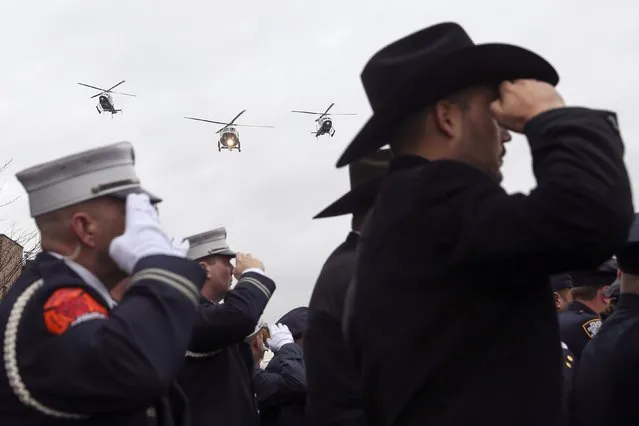 NYPD police helicopters fly over the funeral procession for NYPD officer Wenjian Liu as law enforcement officers salute in the Brooklyn borough of New York January 4, 2015. (Photo by Shannon Stapleton/Reuters)