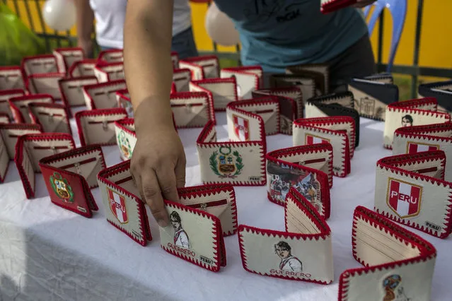 An inmate displays hand made wallets with the image of Peruvian soccer star Paolo Guerrero in the San Juan de Lurigancho prison, in Lima, Peru, Thursday, May 24, 2018. (Photoby Rodrigo Abd/AP Photo)