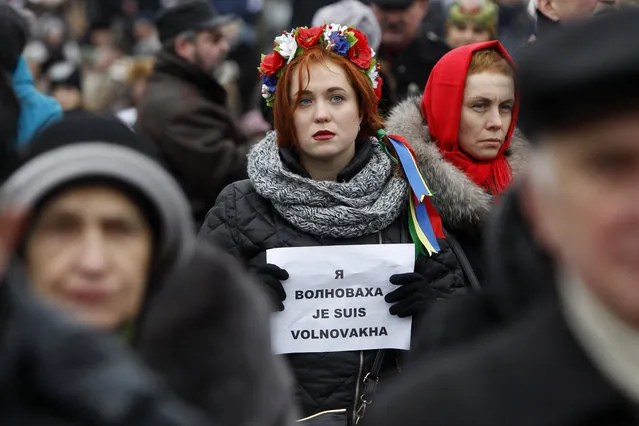 People hold up signs reading “I Am Volnovakha” during a rally at Independence Square in Kiev, Ukraine, in solidarity with the victims of a rocket attack this week that claimed 13 lives on a highway near the eastern town of Volnovakha, on Sunday, January 18, 2015. Ukraine's government accused Russian-backed separatists of launching the rocket attack, which hit a passenger bus, but the rebels have rejected that charge. (Photo by Sergei Chuzavkov/AP Photo)