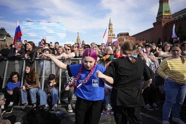 Teenagers dance as thousands of people with Russian national flags gather on Red Square to watch a concert dedicated to the Day of Russia in Moscow, Russia, Sunday, June 11, 2023. (Photo by Alexander Zemlianichenko/AP Photo)