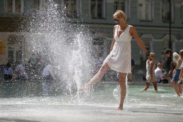 A girl playing with water in a ground fountain in central Moscow, Russia on August 3, 2018. (Photo by Sergei Fadeichev/TASS via Getty Images)