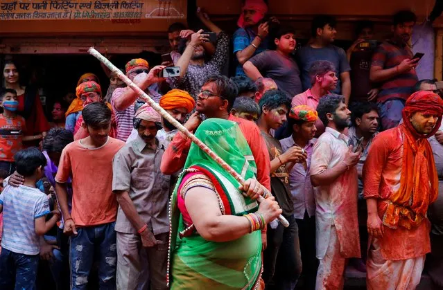 A woman holds a bamboo stick during Lathmar Holi celebrations in the town of Barsana, northern state of Uttar Pradesh, India, March 23, 2021. (Photo by Adnan Abidi/Reuters)